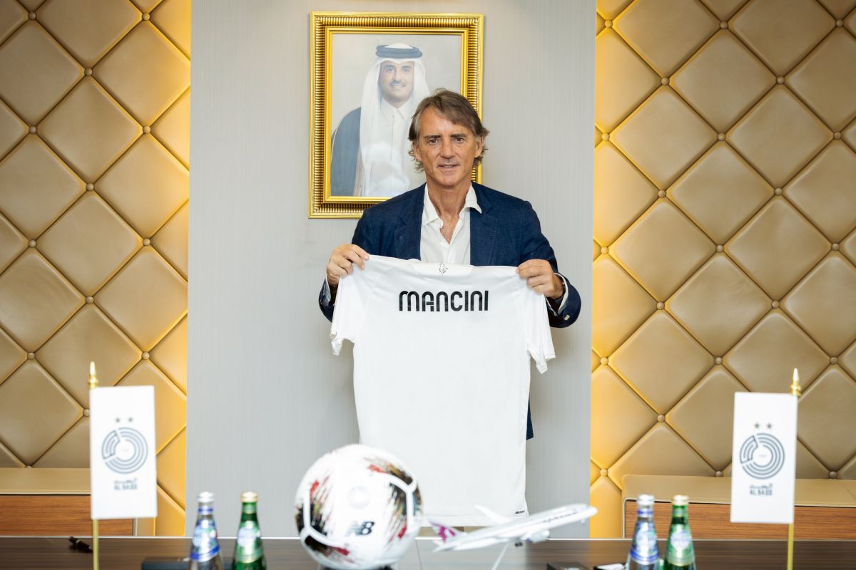 Roberto Mancini holding an Al Sadd shirt at his unveiling